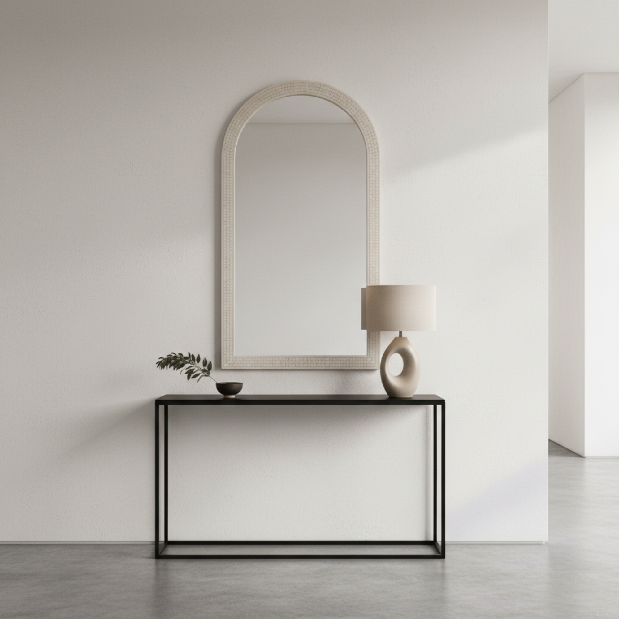 Modern interior with a mirror and console table against a plain wall.
