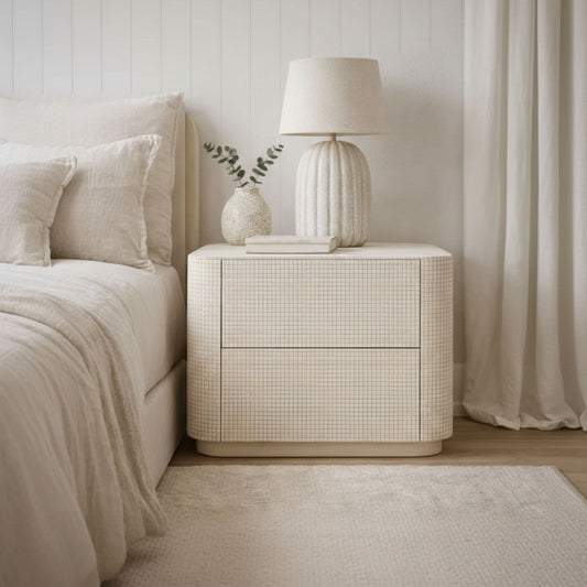Neatly arranged bedroom with a nightstand, lamp, and bed.