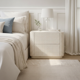 Neatly made bed with a nightstand in a bedroom setting