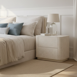 Neatly arranged bedroom with a bed, nightstand, and lamp.