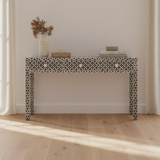 Decorative console table with a geometric pattern in a minimalistic room.