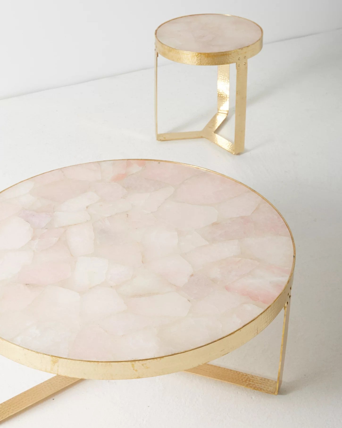 Two round marble tables with gold frames on a white background