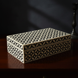 Decorative wooden box with geometric pattern on a dark surface