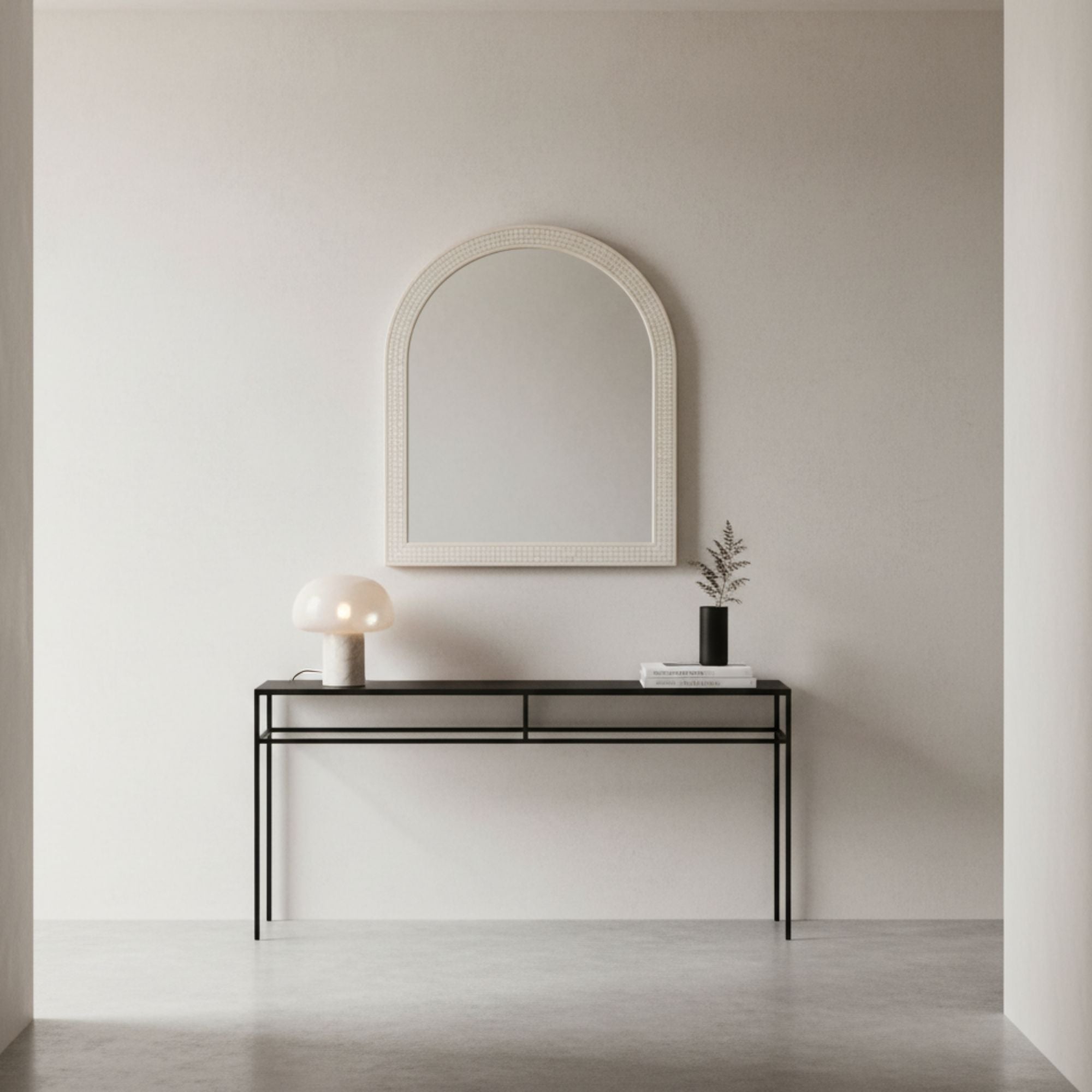 Minimalist interior with a console table and mirror against a plain wall.