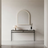 Minimalist interior with a console table and mirror against a plain wall.