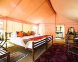 Interior of a luxurious tent with a bed, pillows, and decorative elements.