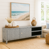 Living room with a chevron-patterned console table, beach-themed artwork, and decorative items.