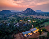 Aerial view of a scenic landscape with mountains and a village at dusk.