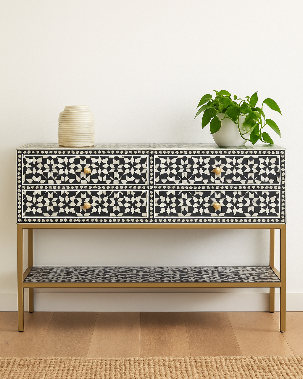 Decorative console table with black and white pattern on a wooden floor.