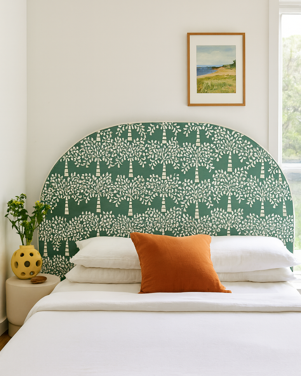 Bedroom with a green patterned headboard, white bedding, and orange pillow.