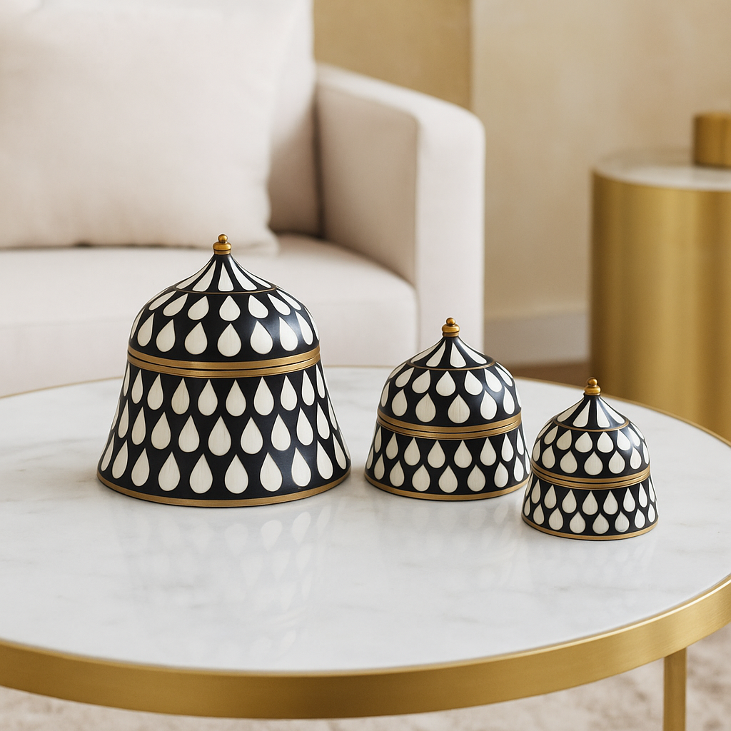 Set of three black and white patterned containers on a marble table with a blurred background