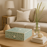 Decorative box on a coffee table with a couch and lamp in the background
