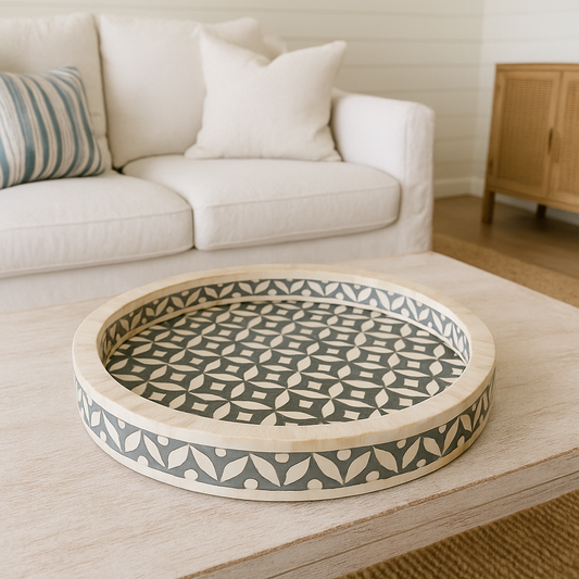 Decorative round tray with geometric pattern on a wooden surface in a living room setting.
