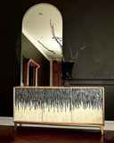 Decorative cabinet with a mirror above it in a room setting.