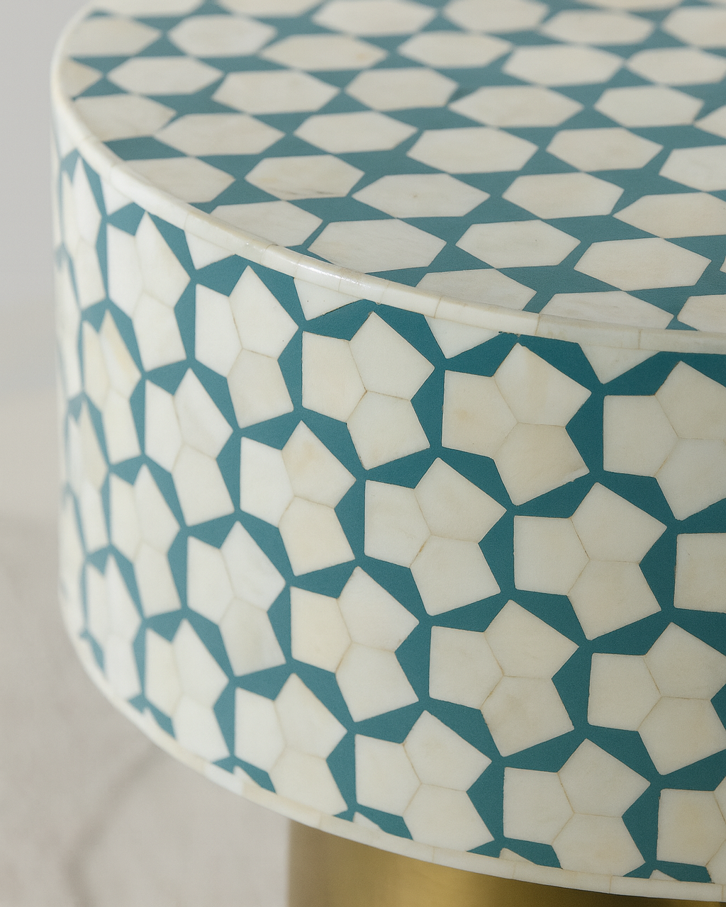 Round stool with geometric blue and white pattern on a plain background