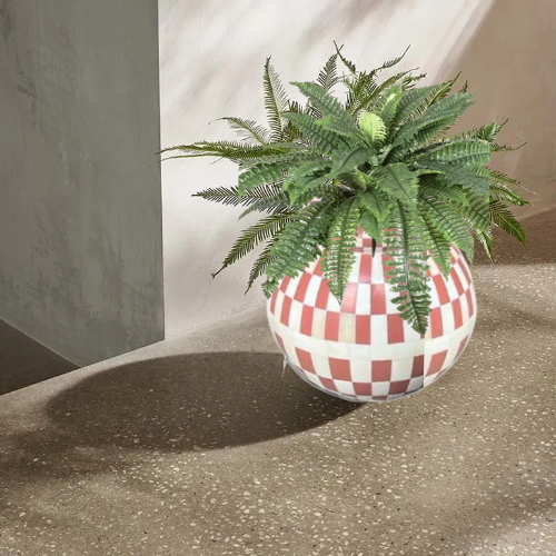 Decorative plant in a checkered pot on a textured surface