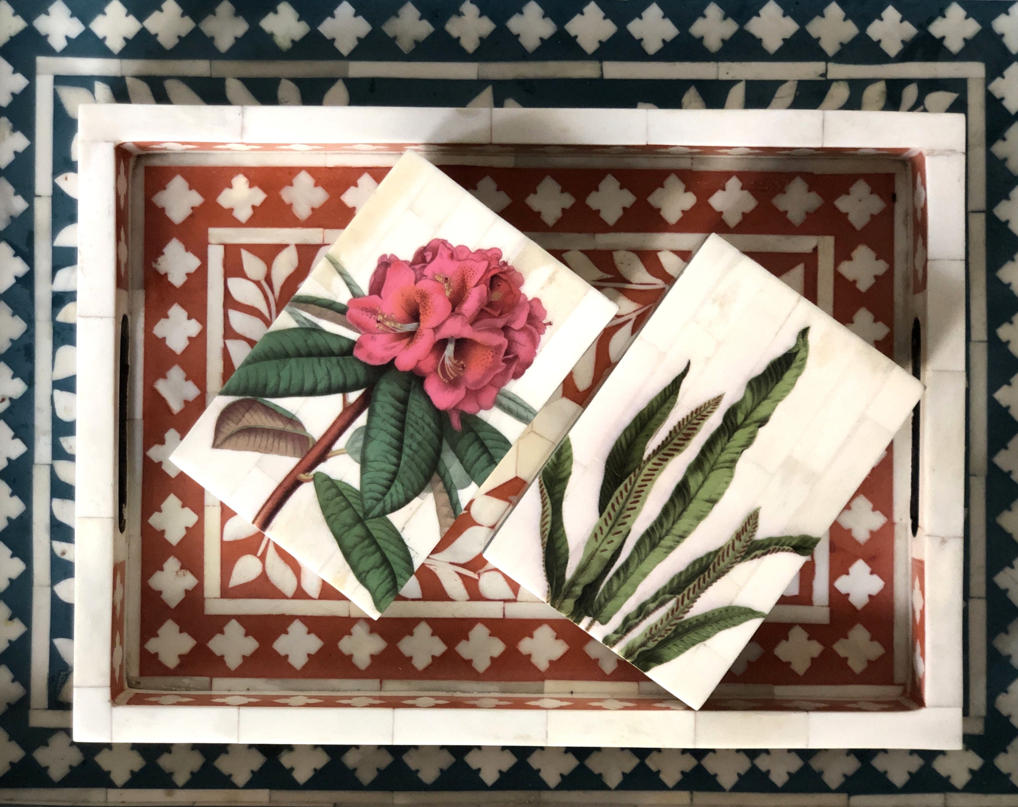 Decorative tray with floral design on a patterned tile background
