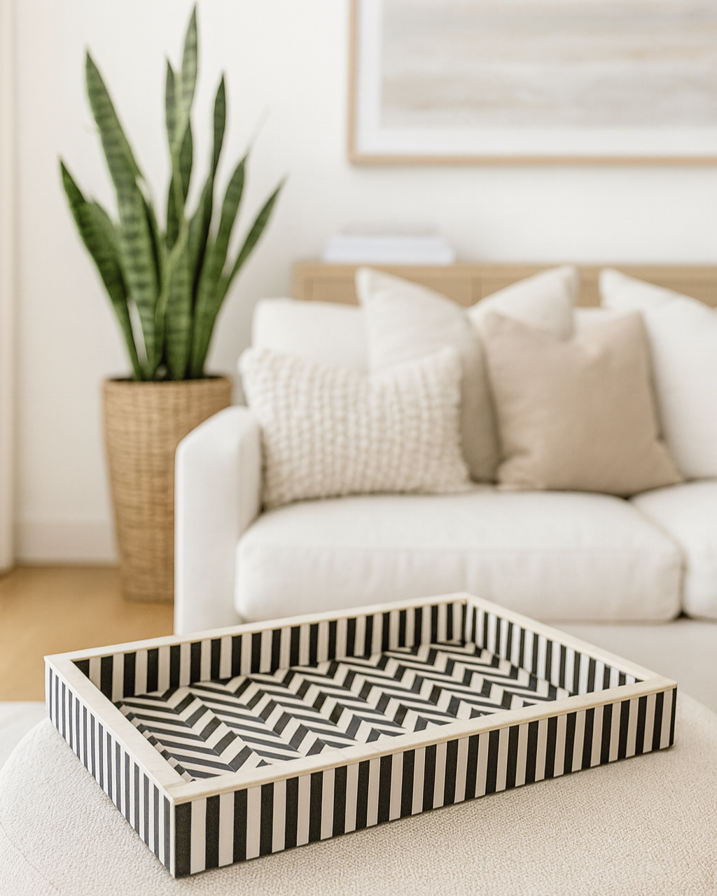 Black and white striped wooden tray on a coffee table with a living room background
