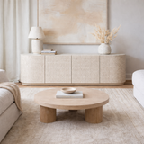 Modern living room with a wooden coffee table and decorative items.
