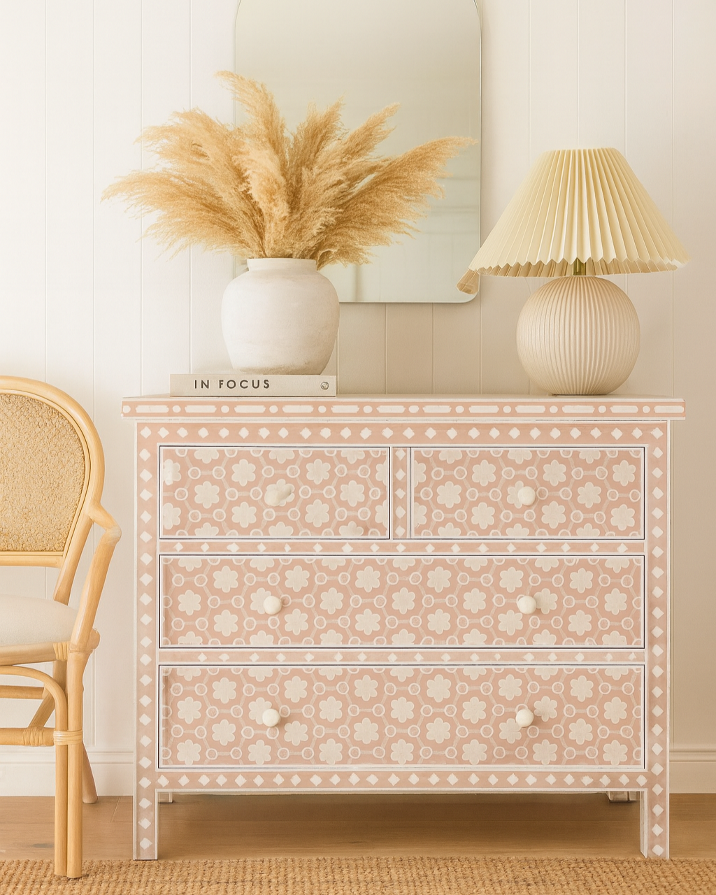 Decorative chest of drawers with intricate patterns, a lamp, and a chair in a room setting.