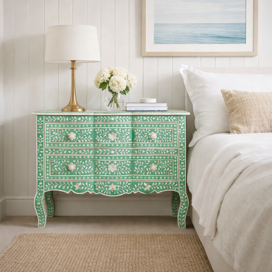 Decorative green nightstand with floral patterns in a bedroom setting.
