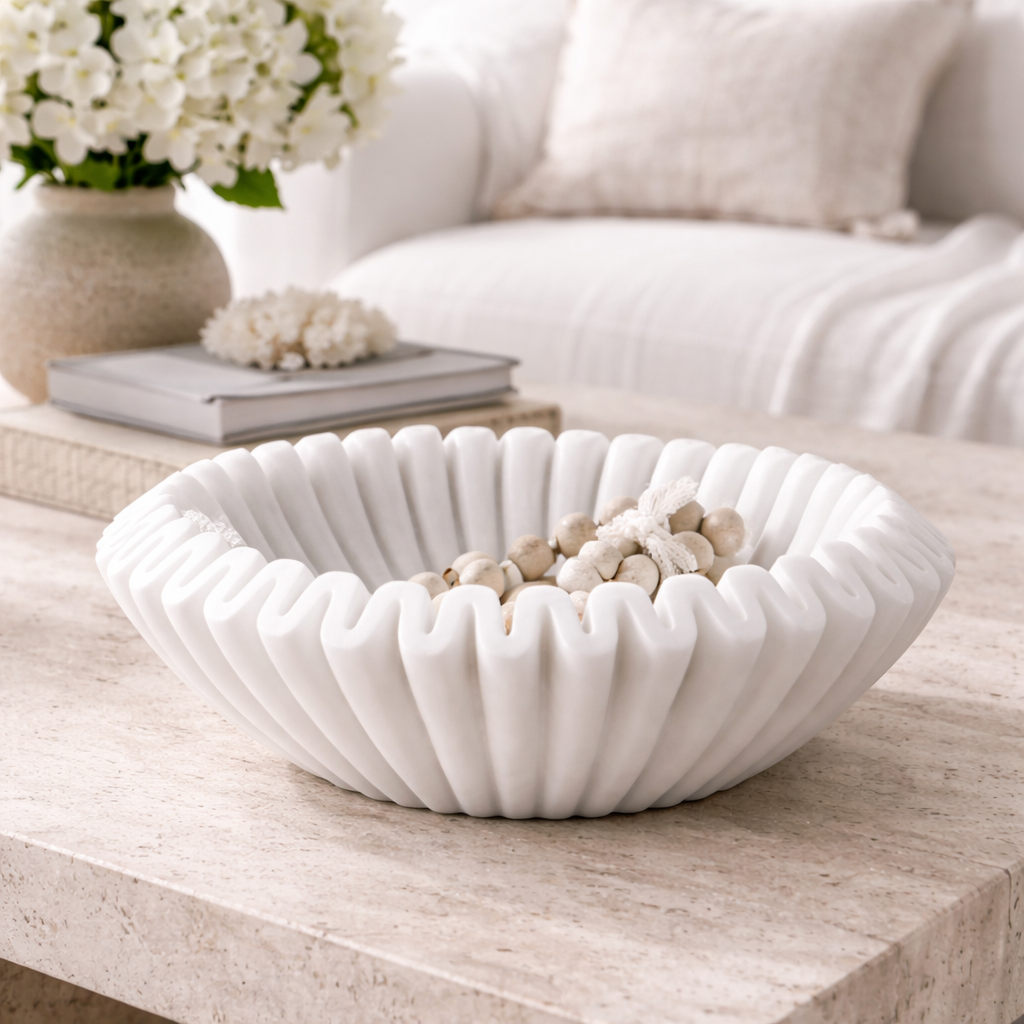 White decorative bowl with pebbles on a coffee table in a living room setting.