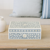 Decorative box with floral patterns on a wooden surface