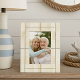 Decorative photo frame with a picture of two people hugging on a wooden surface.
