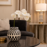Decorative vase with white flowers on a table in a living room setting