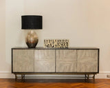 Wooden sideboard with decorative lamp and box against a beige wall