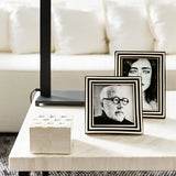 Two photo frames on a coffee table with a white couch in the background