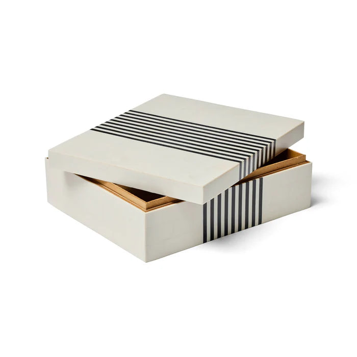 White jewelry box with black striped pattern on a white background