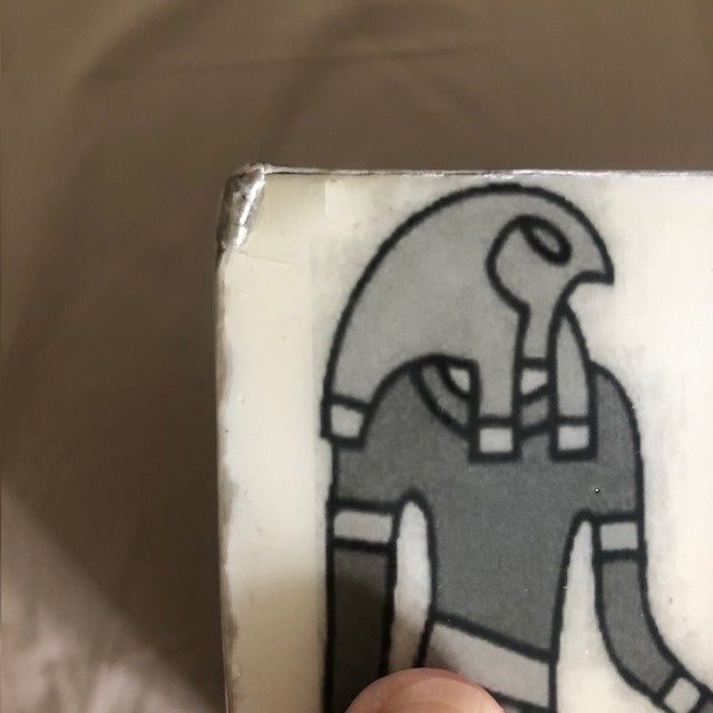 Close-up of a cartoon character on a product packaging with a hand holding it.