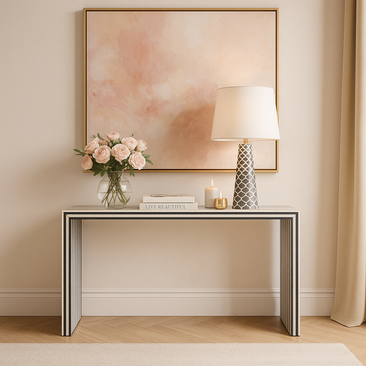 Console table with decorative items against a wall with a framed abstract painting.