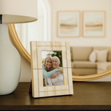 Wooden photo frame with a picture of two women on a table in a living room.