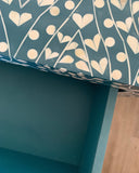 Teal surface with white heart and line pattern