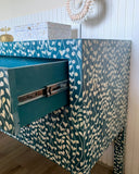 Patterned furniture with a blue and white design on a wooden floor.