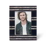 A picture frame with black and natural color inlay, designed to hold a 5 x 7 photo, displaying a man's portrait inside.