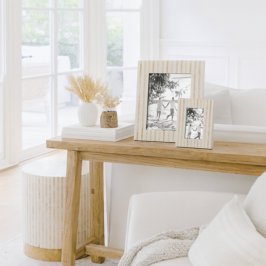 Wooden console table with decorative items in a bright living room.