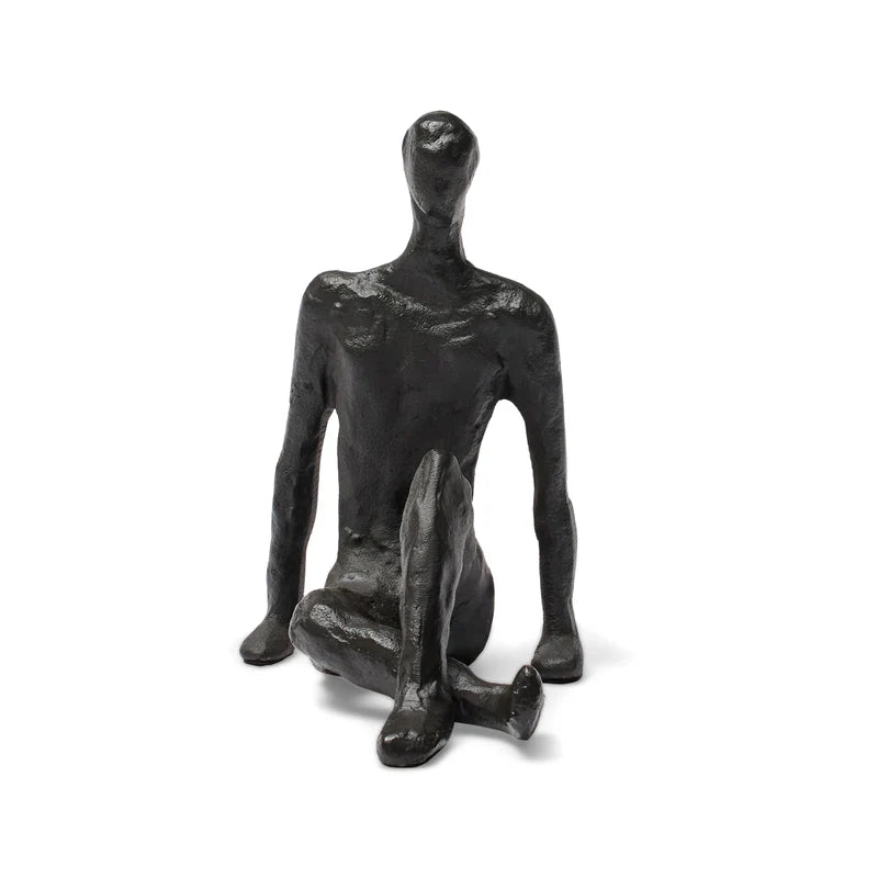 Abstract black sculpture of a seated figure on a white background