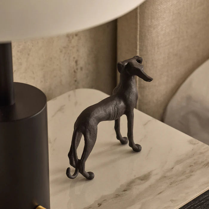 Decorative black dog figurine on a marble surface with a blurred background