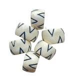 White beads with blue zigzag patterns on a white background