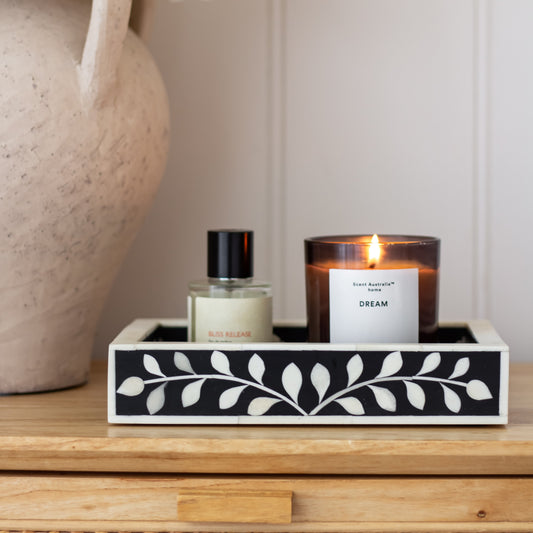 Candle and perfume bottle in a decorative box on a wooden surface