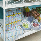 Display of decorative items including bowls and packaging on a white shelf.