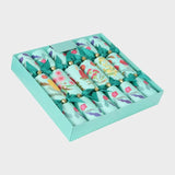 Set of decorative crackers in a green box on a light gray background