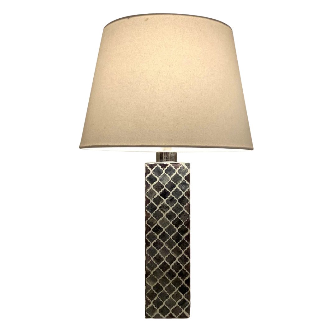 Table lamp with a textured cylindrical base and beige lampshade on a white background