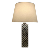 Table lamp with a textured cylindrical base and beige lampshade on a white background