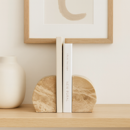 Marble bookends on a shelf with a framed picture in the background