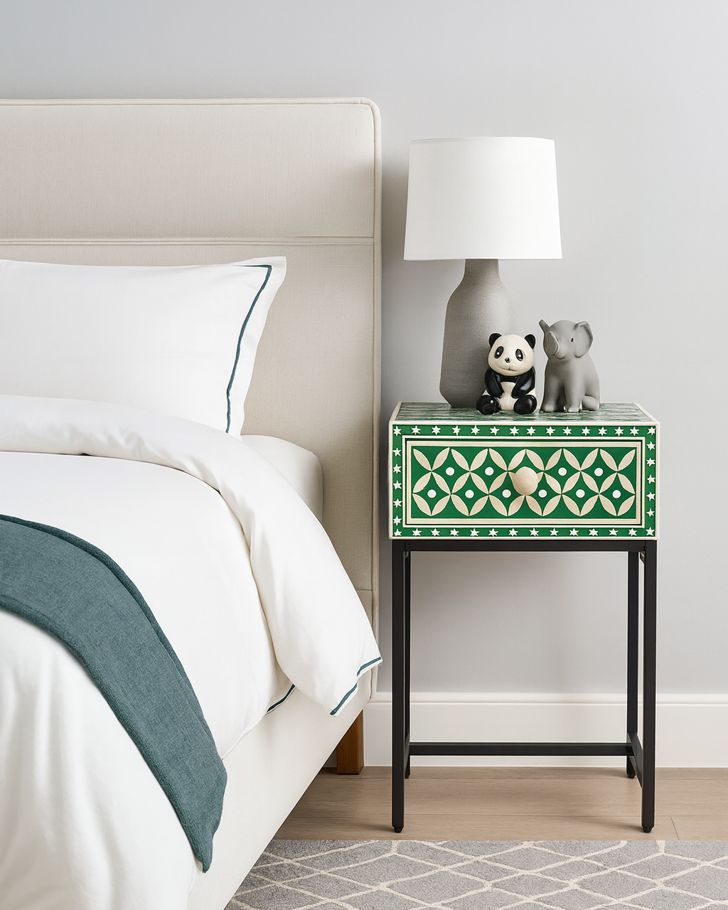 Green nightstand with decorative items next to a bed in a bedroom setting