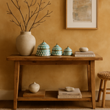 Wooden console table with decorative items against a warm-colored wall.